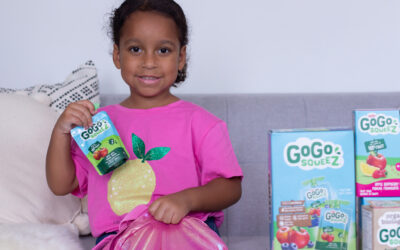 Little girl holding fruit sauce pouch