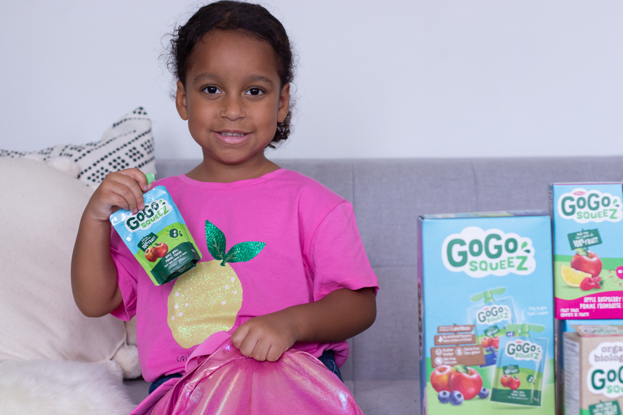 Little girl holding fruit sauce pouch