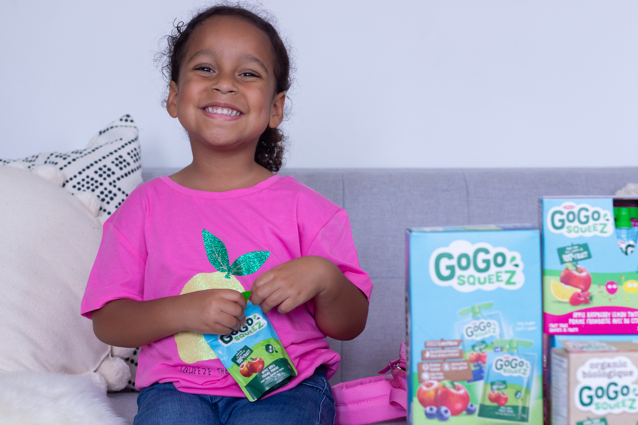 toddler smiling with fruit sauce pouch