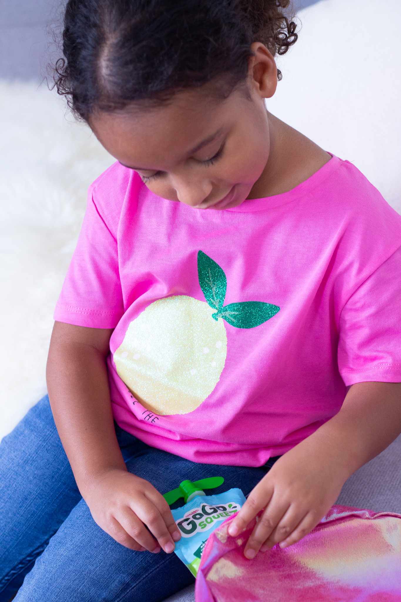 Toddler putting fruit pouch in backpack